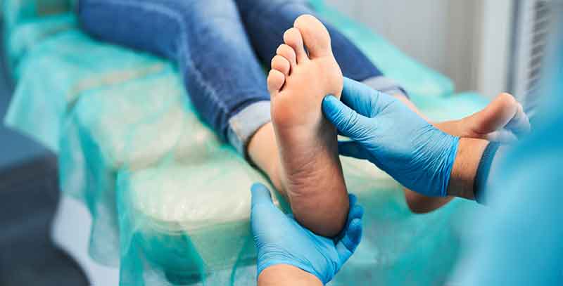 Doctor inspecting bottom of patient's foot